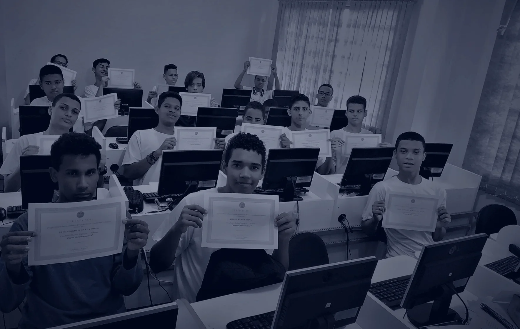 Jovens aprendizes em sala segurando seus certificados